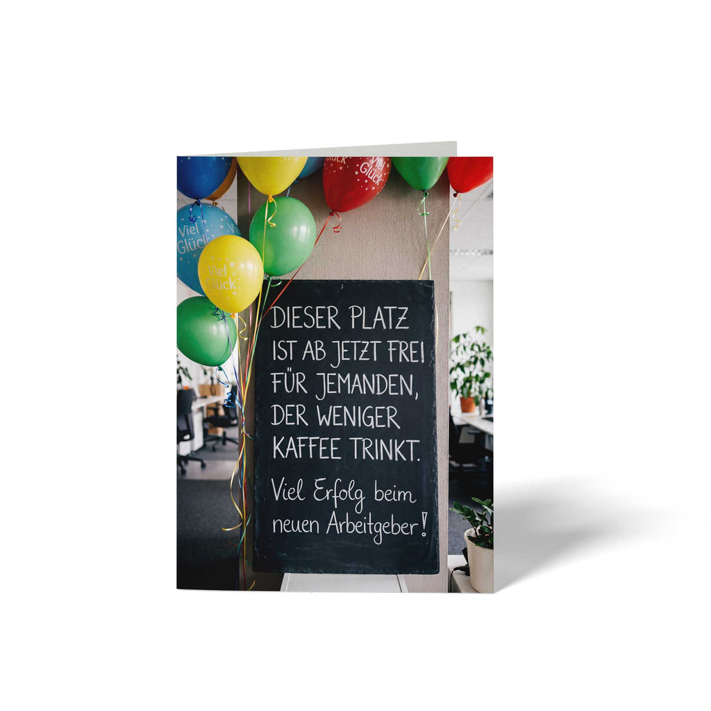 Vorderseite der geschlossenen A6 Karte zum Abschied von GHG Supplies. Eine Schiefertafel im Büro mit bunten Luftballons und dem lustigen Spruch Dieser Platz ist ab jetzt frei für jemanden, der weniger Kaffee trinkt. Viel Erfolg beim neuen Arbeitgeber!