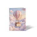 Vorderseite der geschlossenen A6 Karte zur Geburt von GHG Supplies. Ein rosa-weiß gestreifter Heißluftballon fliegt in den Wolken mit einem Schild Ein neues Abenteuer beginnt... Alles Liebe zur Geburt!.