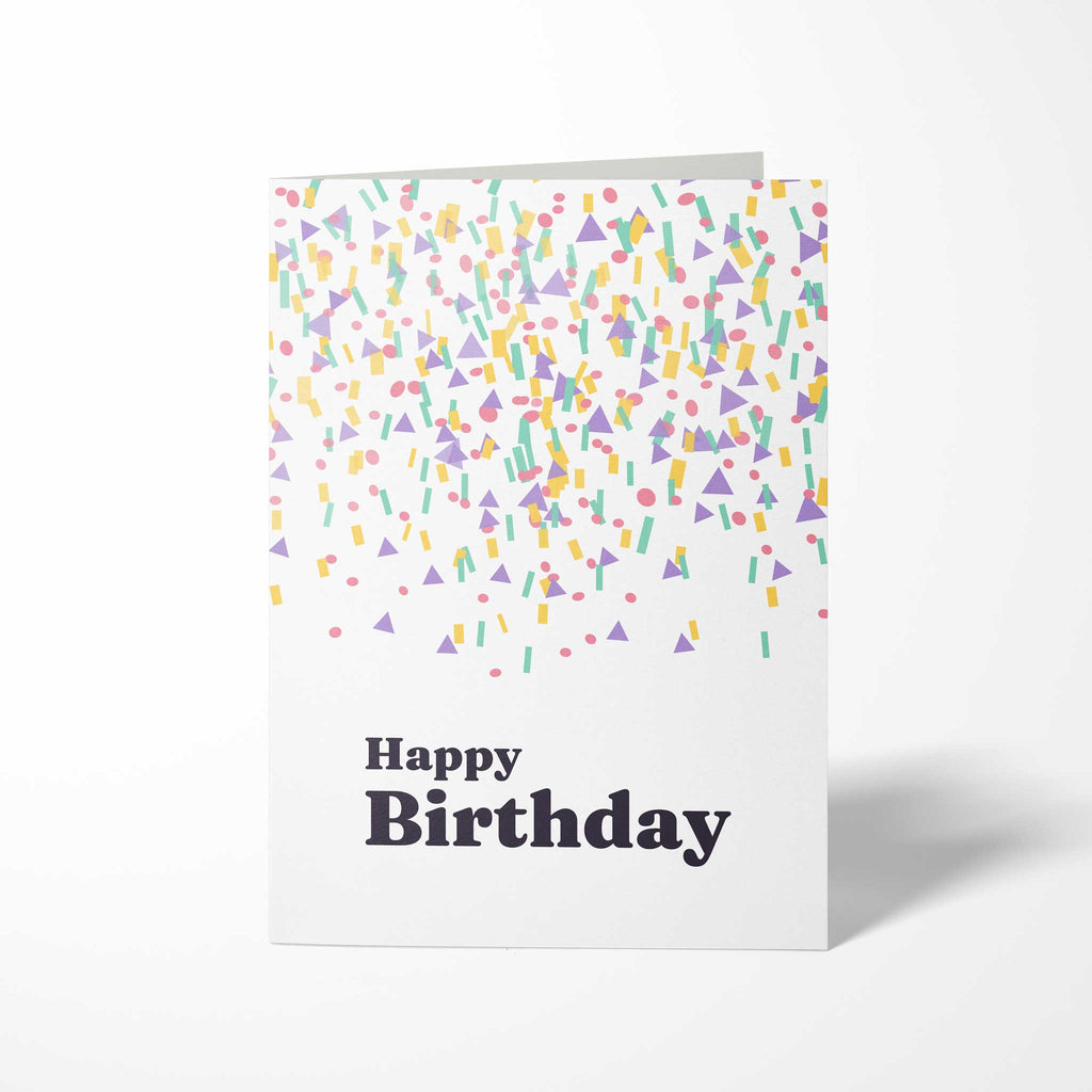 Vorderansicht der hochkant gefalteten B6 Geburtstagskarte mit bunten geometrischen Konfetti-Formen in Pastelltönen und dem dunklen Schriftzug Happy Birthday.