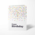 Vorderansicht der hochkant gefalteten B6 Geburtstagskarte mit bunten geometrischen Konfetti-Formen in Pastelltönen und dem dunklen Schriftzug Happy Birthday.