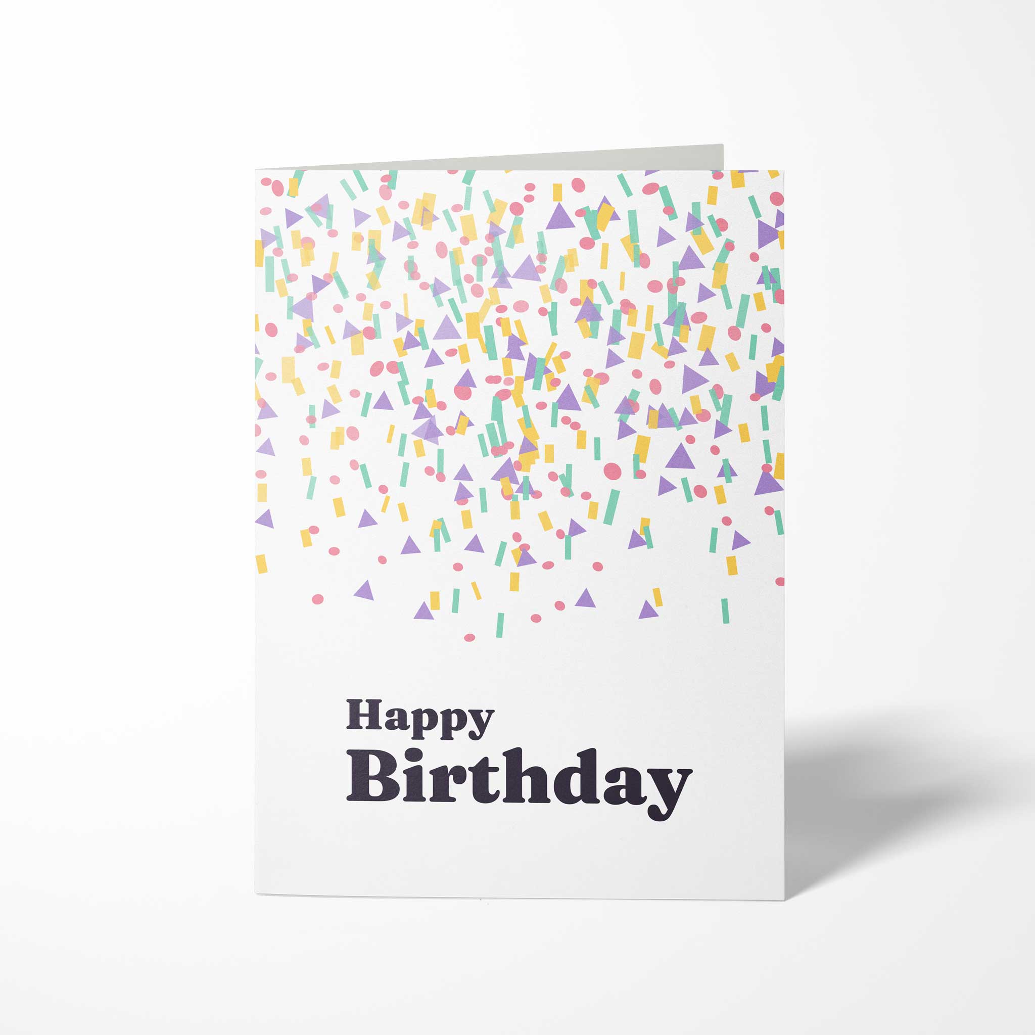 Vorderansicht der hochkant gefalteten B6 Geburtstagskarte mit bunten geometrischen Konfetti-Formen in Pastelltönen und dem dunklen Schriftzug Happy Birthday.