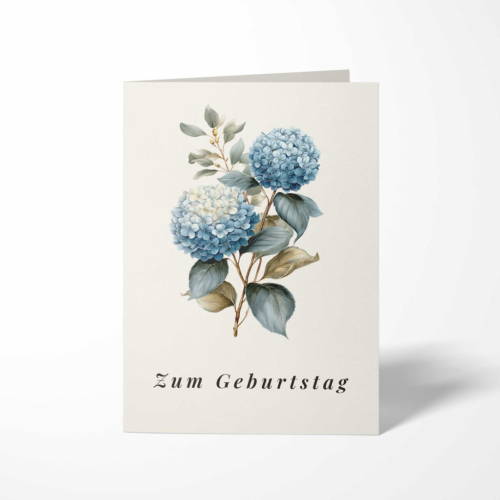 Vorderansicht der hochkant gefalteten B6 Geburtstagskarte mit einer klassischen botanischen Illustration zweier blauer Hortensienblüten und dem kursiven Schriftzug Zum Geburtstag.
