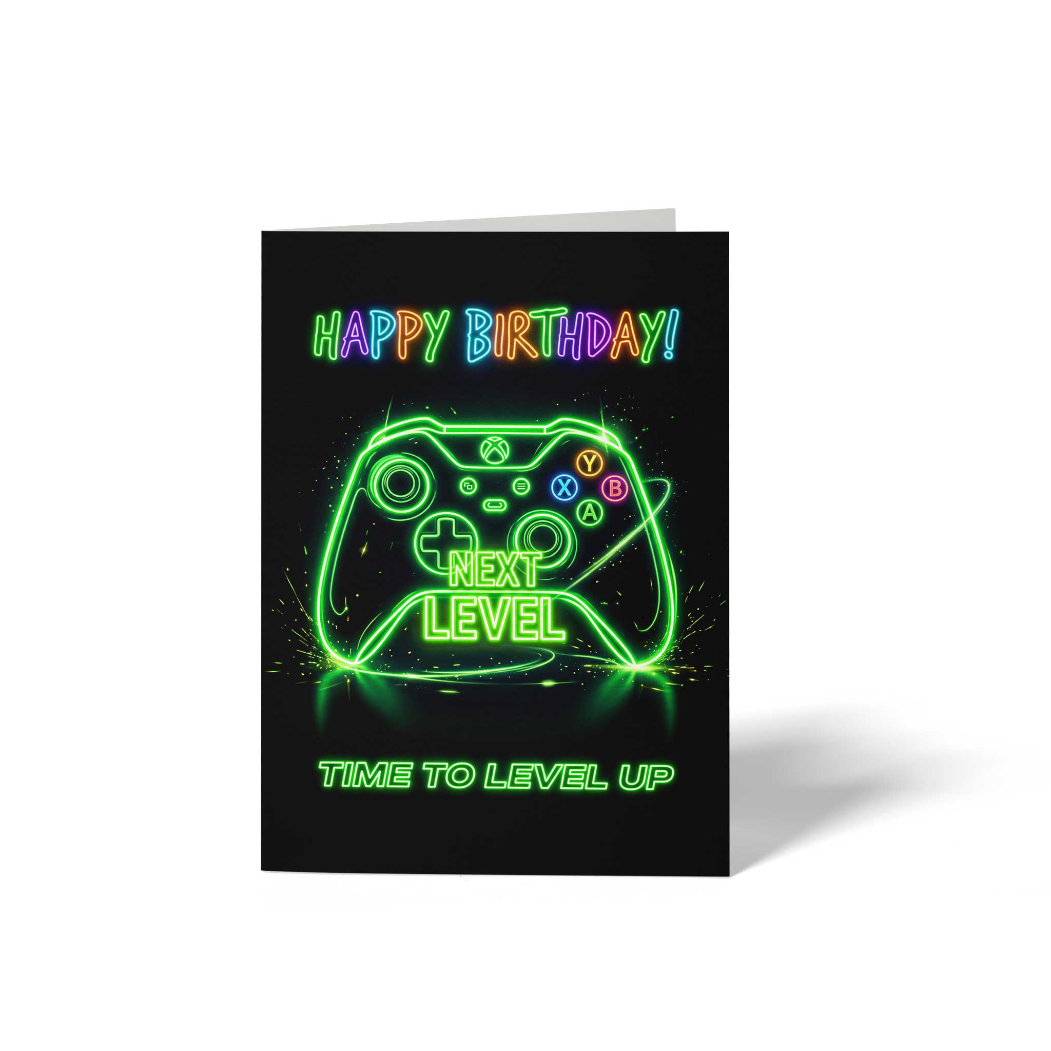 Vorderansicht der hochkant gefalteten A6 Geburtstagskarte mit tiefschwarzem Hintergrund. Das Motiv zeigt die leuchtend grüne Silhouette eines Gaming-Controllers im Neon-Stil mit der integrierten Aufschrift NEXT LEVEL. Oben drüber prangt der farbenfrohe Neonschriftzug HAPPY BIRTHDAY! in Regenbogenfarben, während am unteren Rand die Zeile TIME TO LEVEL UP in grün konturierter Leuchtschrift steht.