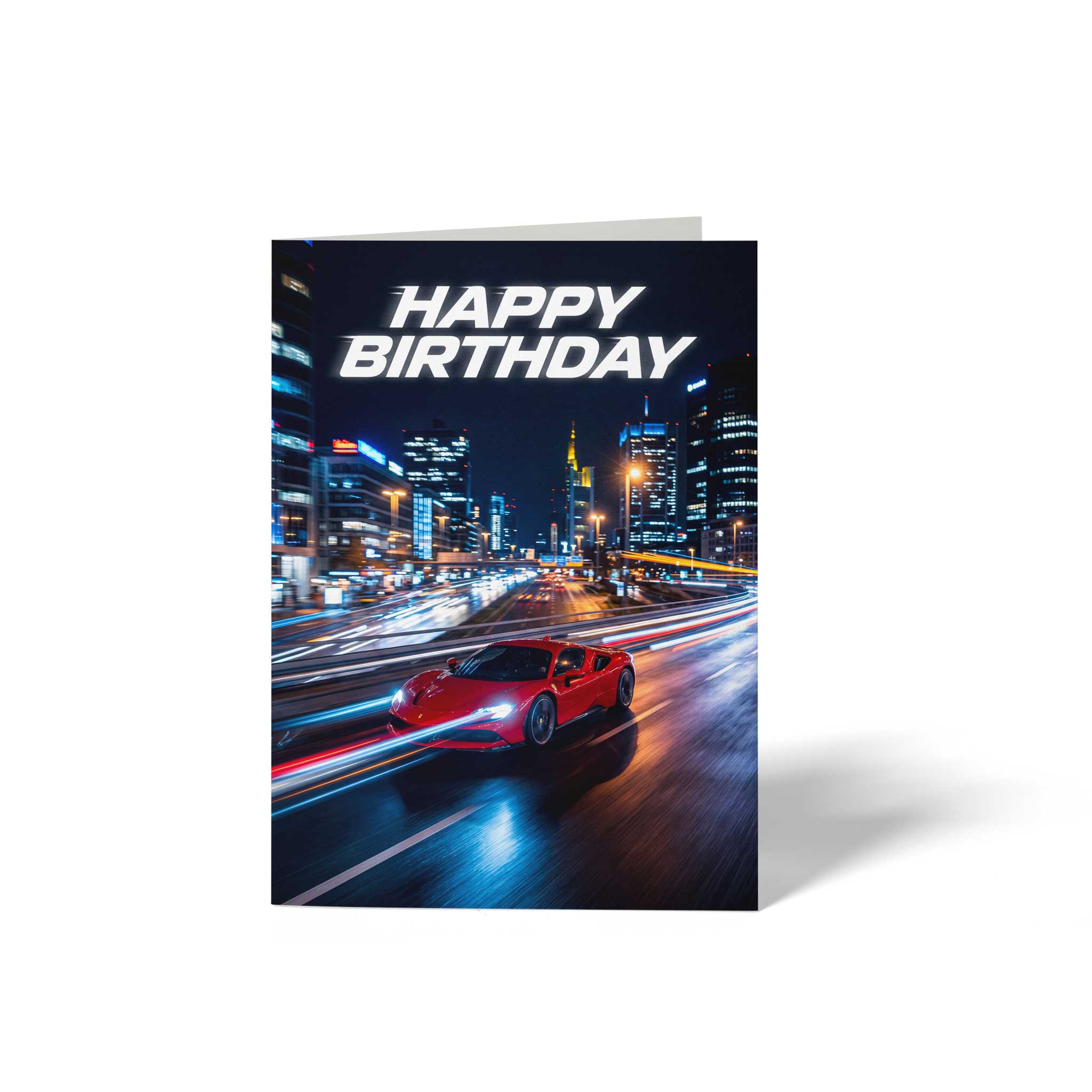Vorderseite der geschlossenen A6 Geburtstagskarte von GHG Supplies. Ein roter Sportwagen fährt bei Nacht mit hoher Geschwindigkeit durch eine Großstadt mit Lichtspuren, darüber der Text HAPPY BIRTHDAY.