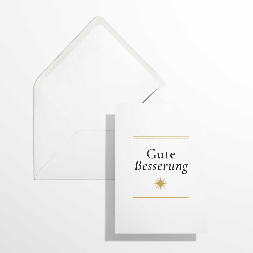 Elegante Genesungskarte Gute Besserung im Format B6 flach liegend neben dem geöffneten, naturweißen Premium-Briefumschlag mit klassisch spitzer Verschlussklappe.