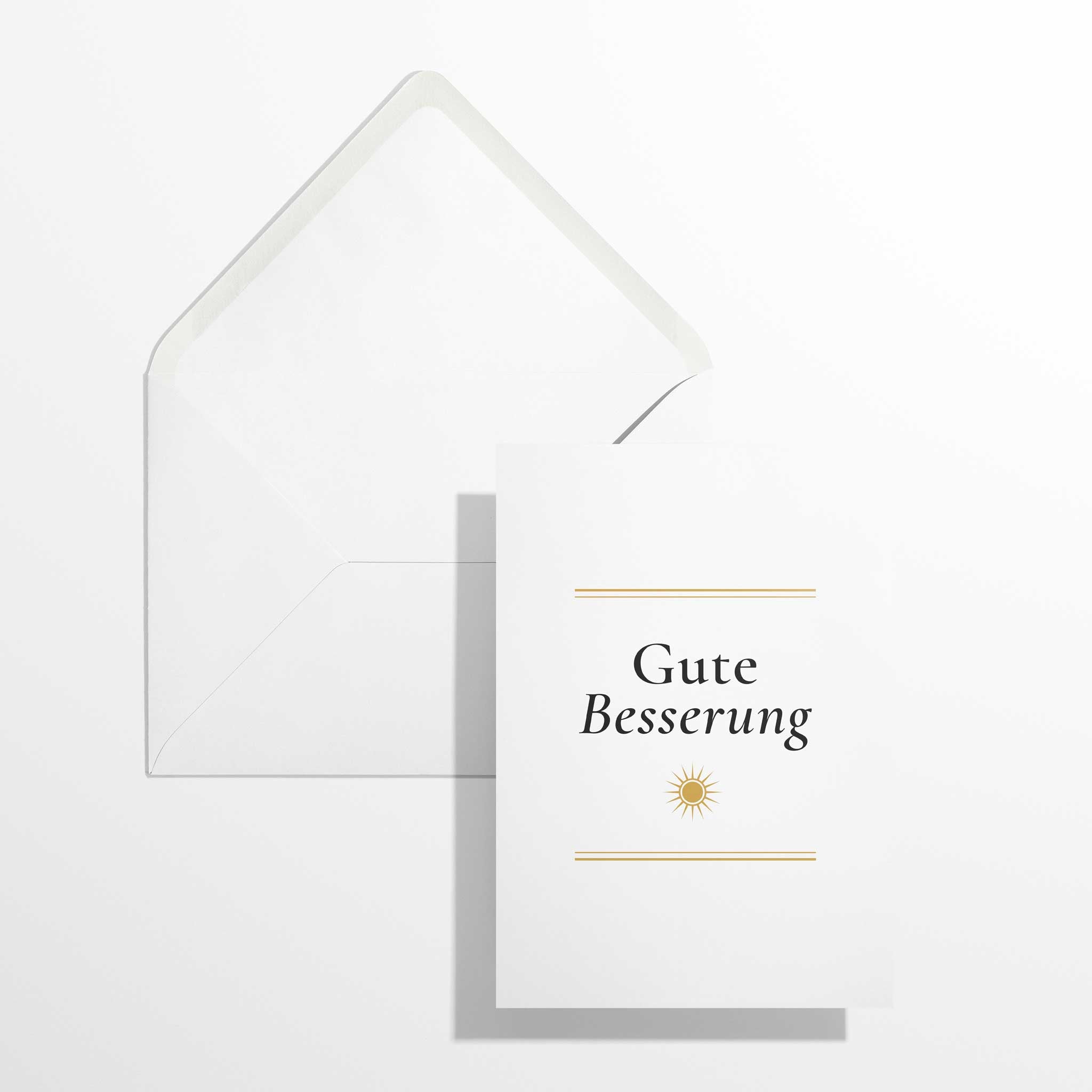 Elegante Genesungskarte Gute Besserung im Format B6 flach liegend neben dem geöffneten, naturweißen Premium-Briefumschlag mit klassisch spitzer Verschlussklappe.
