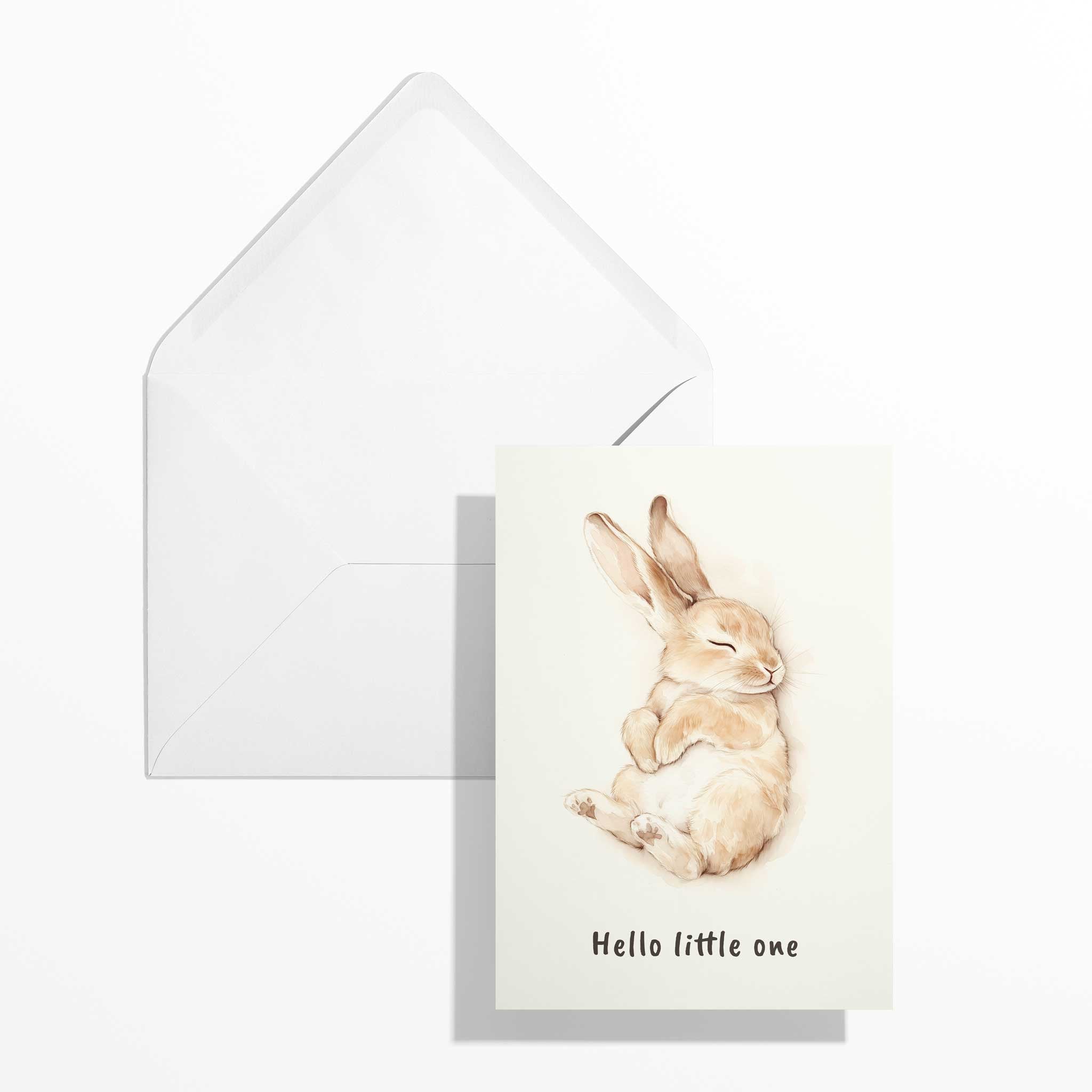 Niedliche Babykarte mit Aquarell-Hase im Format B6 flach liegend neben dem geöffneten, naturweißen Premium-Briefumschlag mit klassisch spitzer Verschlussklappe.