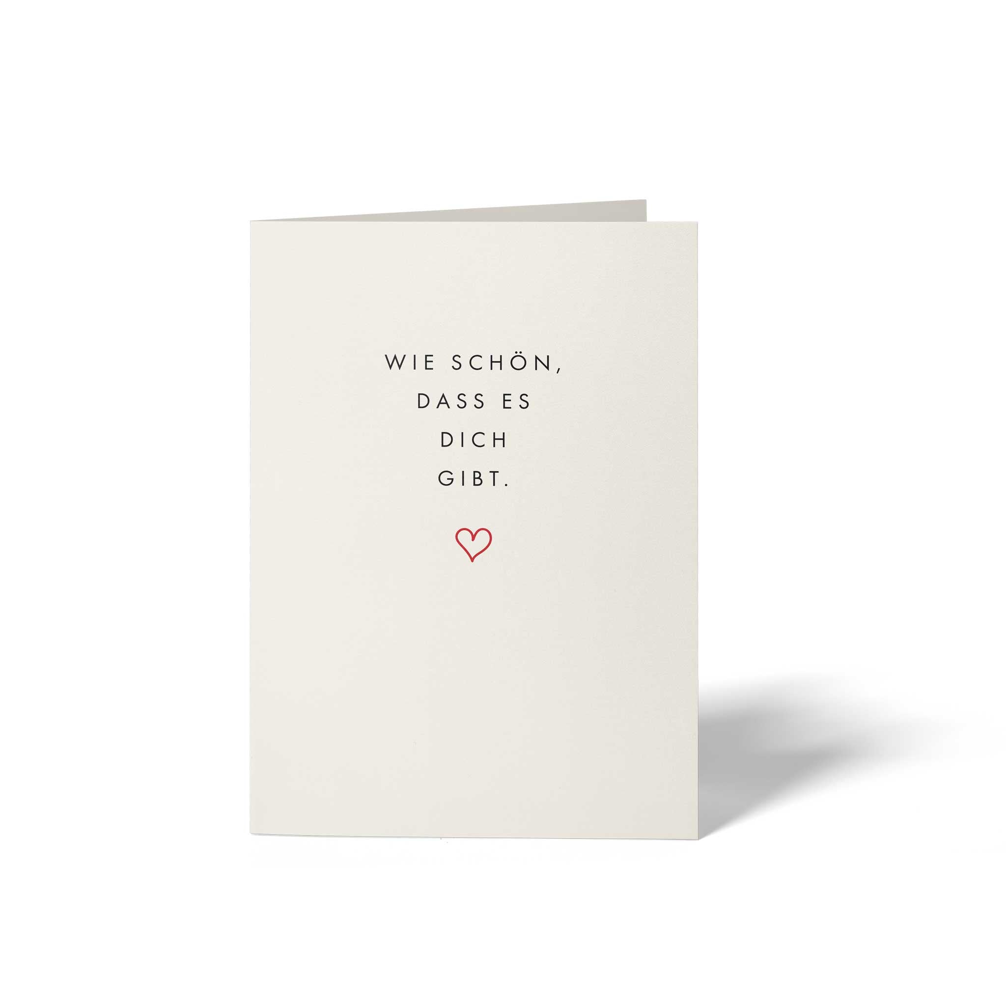 Vorderseite der geschlossenen A6 Glückwunschkarte von GHG Supplies auf edlem Soft-White Olin-Papier mit dem minimalistischen Text Wie schön, dass es dich gibt. und einem kleinen roten Herz.